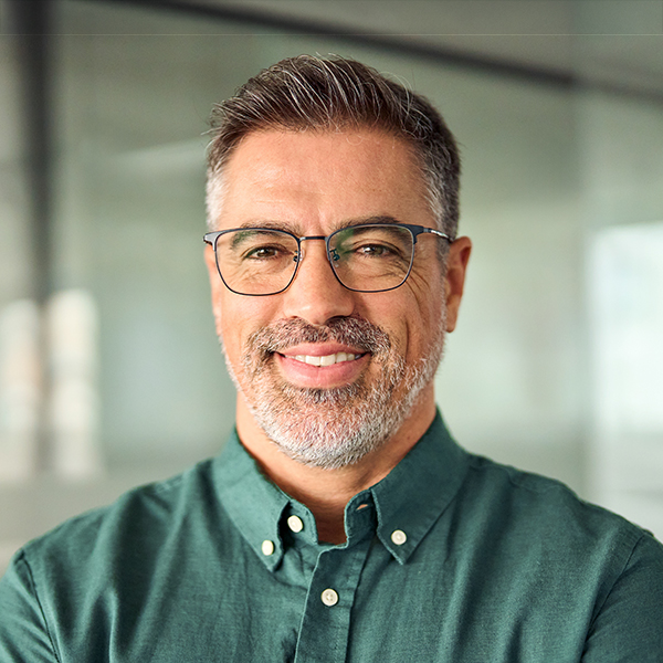 Smiling 45 years old business man wearing glasses in office, headshot portrait.