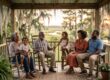 Three generations of a family together on a raised coastal Louisiana home porch at sunset